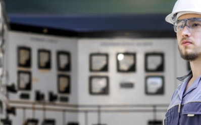 Power plant worker holding a sheet of paper in a control room